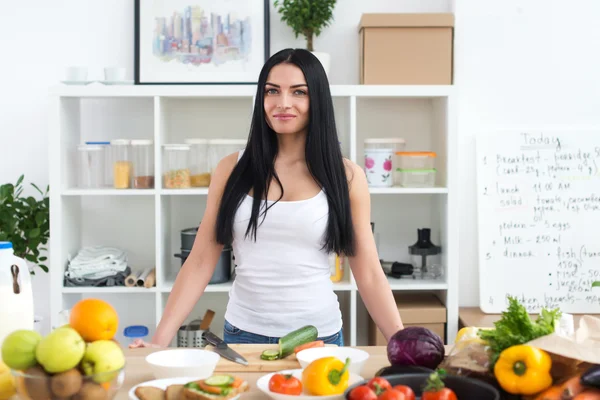 Young woman standing in the kitchen — Stock Photo, Image