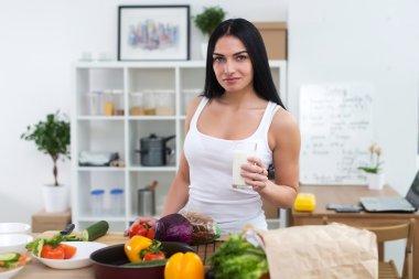 Young woman standing next to kitchen table  