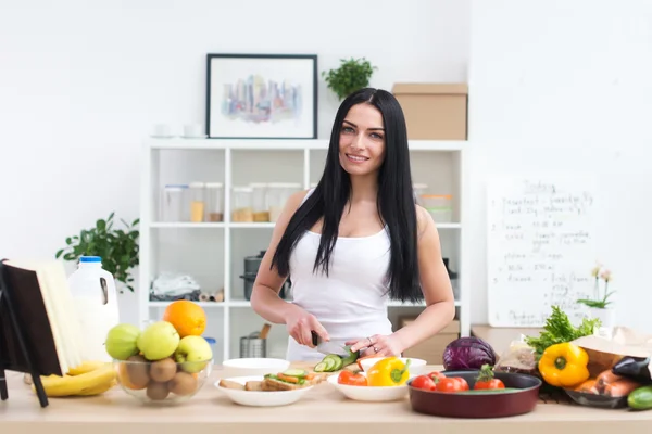 Young beautiful housewife in the kitchen — Stockfoto