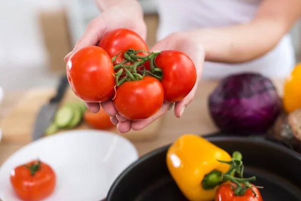 Mãos femininas segurando tomates vermelhos — Fotografia de Stock