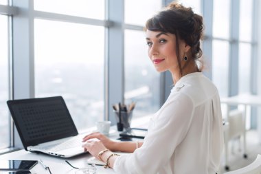 Young female office employee using laptop 