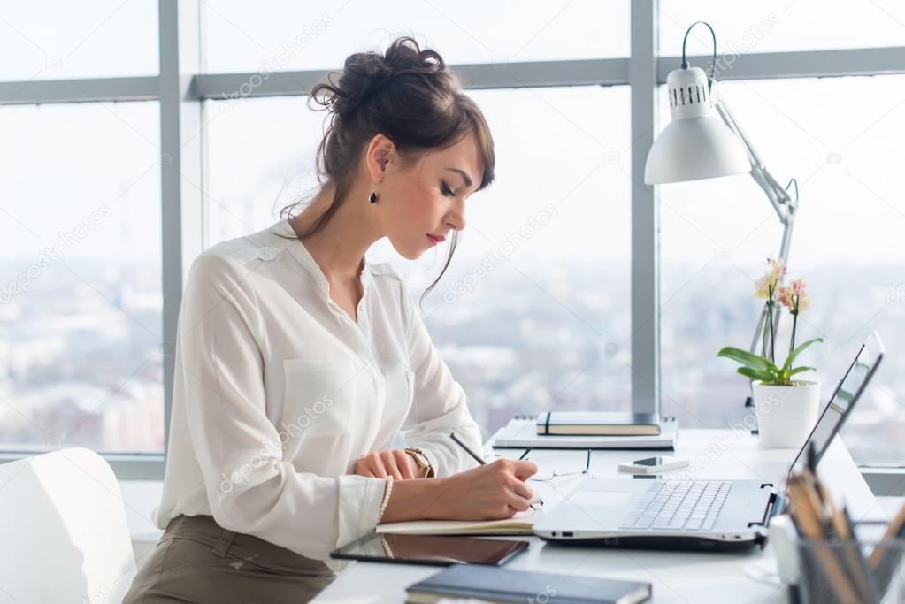 Young woman working as an office manager Stock Photo by ©undrey 108871150