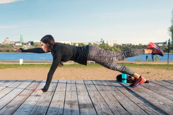 Mujer haciendo levantado pierna tablón yoga —  Fotos de Stock