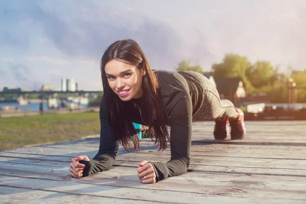 Sporty giovane donna facendo gomito tavola — Foto Stock