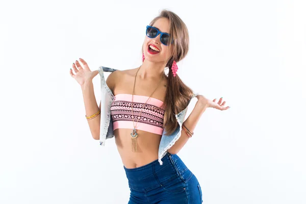 Jovem modelo feminina de pé lateralmente, dobrando seu corpo, colocando braço na anca, usando óculos escuros e acessórios brilhantes . — Fotografia de Stock