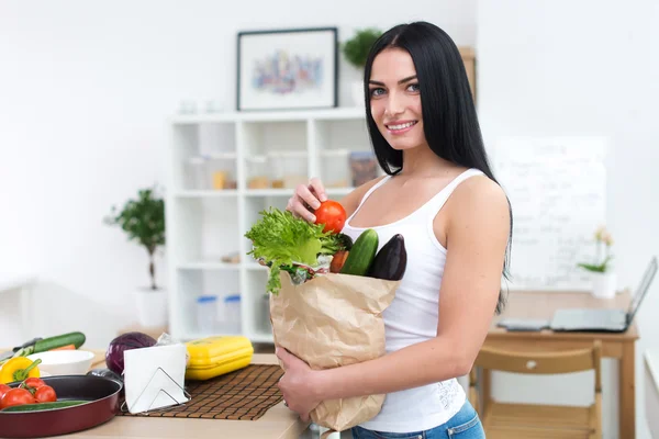 Female cook holding bag full of greens — Stock Image Female cook holding bag full of greens Royalty Free Stock Photos