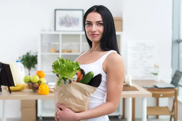 Mulher segurando saco de papel vegetais frescos cheios . — Fotografia de Stock