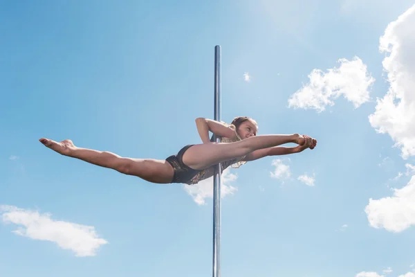 Pole dance mujer en forma de ejercicio con pilón al aire libre — Foto de Stock