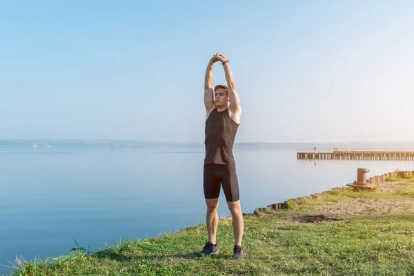 Fit atletiska man värmer upp — Stockfoto