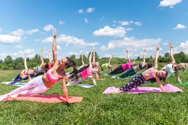 Group of fit girls going side plank exercise — Stock Photo, Image