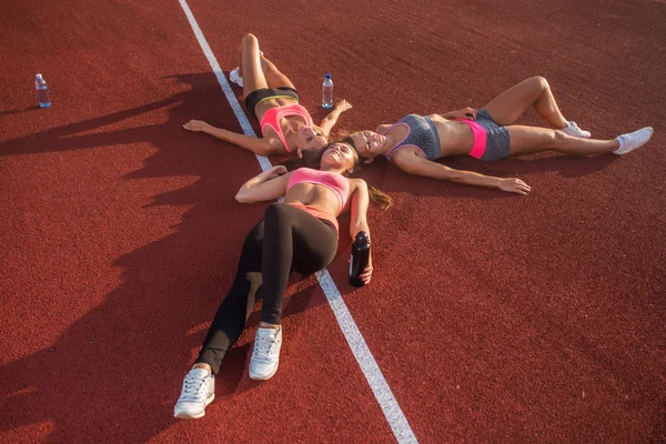 Fitness kvinnor vilande på golvet — Stockfoto
