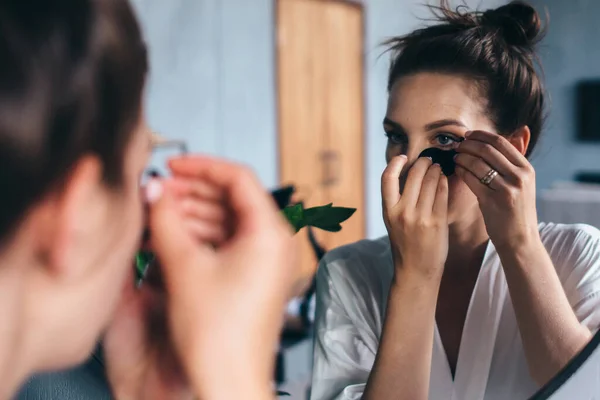 年轻女人在家照顾她的面部皮肤 — 图库照片