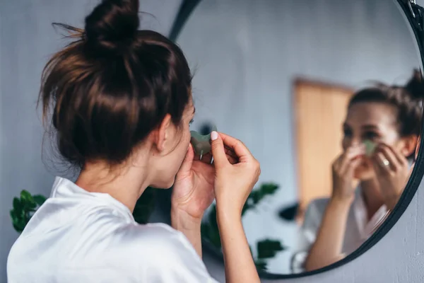 Mujer joven cuida su piel facial en casa — Foto de Stock