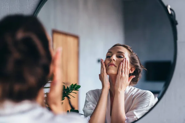 Vrouw brengt schuim aan op haar gezicht, reinigt haar huid. — Stockfoto