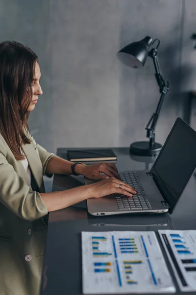 Kvinna som arbetar vid sitt skrivbord med en bärbar dator — Stockfoto