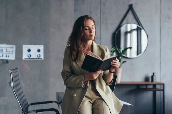 Žena podnikatel v práci čtení poznámek v plánovači — Stock fotografie