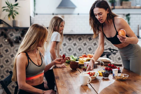 Sportig kvinna som serverar hälsosam mat till sina nära och kära — Stockfoto