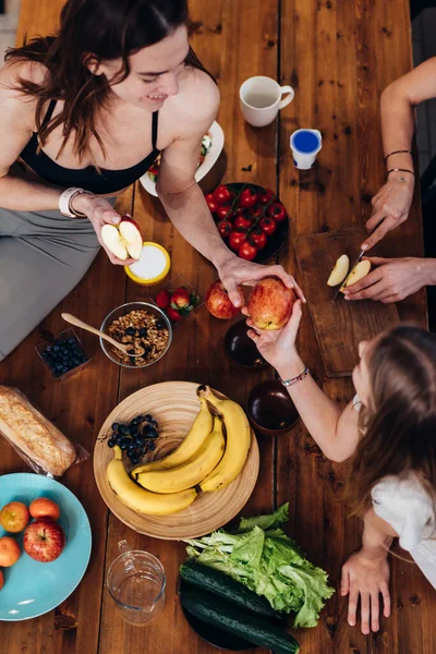 Deportivas chicas en la cocina comiendo manzanas y frutas — Foto de Stock