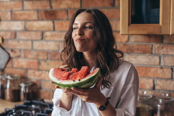 Frau zu Hause isst Wassermelone in der Küche — Stockfoto