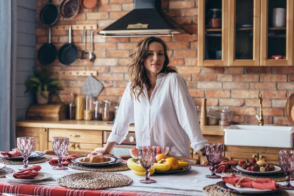 Frau hat den Tisch gedeckt und ist bereit, Gäste zu empfangen. — Stockfoto