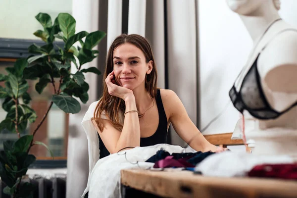 Vrouwelijke modeontwerper zit op haar werkplek — Stockfoto