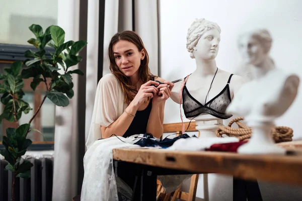 Vrouwelijke lingerie ontwerper zit in haar werkplaats — Stockfoto