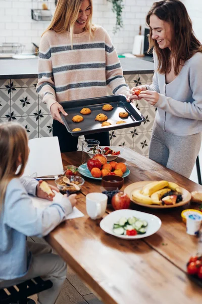 Unga kvinnor i köket matlagning, bakning kakor — Stockfoto
