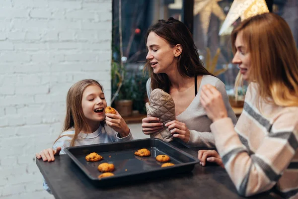 Mädchen probieren frisch gebackene Plätzchen. — Stockfoto