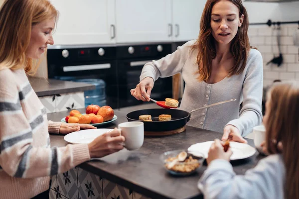Junge Frau frittiert Quarkkuchen oder Sirniki und verwöhnt ihre Gäste — Stockfoto