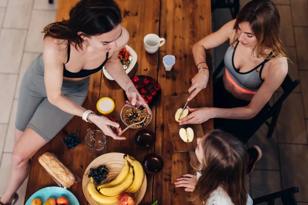 Sportieve meisjes in de keuken koken gemakkelijke maaltijden. — Stockfoto