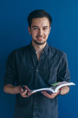 Elleri açık neşeli bir adam mutlu bir şekilde gülümsüyor, sıradan giyiniyor..