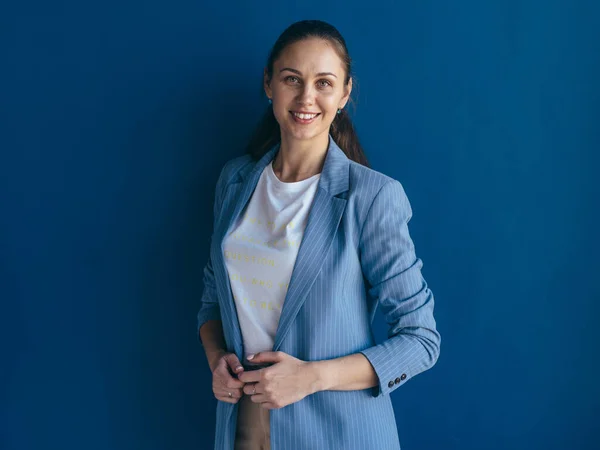 Porträt einer lächelnden Frau, die vor blauem Hintergrund posiert — Stockfoto