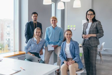 Muhtelif iş adamları ofiste yan yana duruyorlar.