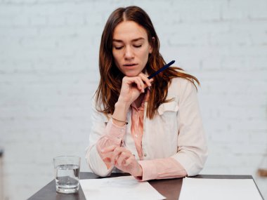 Genç doktor iş yerinde oturur ve notlarını okur.