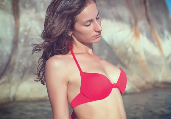 Jovem mulher ao ar livre retrato na praia rochosa selvagem pedra paisagem vista mar em biquíni vermelho maiô — Fotografia de Stock