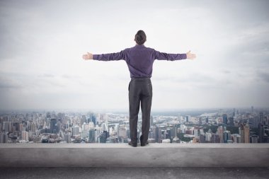 Confident businessman purple shirt and trausers standing on edge of roof with his hands sides front magnificent view city clipart