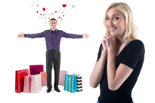 Jeune homme avec le sourire et les coeurs volants autour de sacs debout cadeaux après les achats féliciter heureuse fille magnifique — Photo