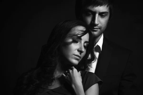Kudrnatá bruneta dívka a pohledný chlap v obleku ideální romantický pár. Černá bílá portrét. — Stock fotografie