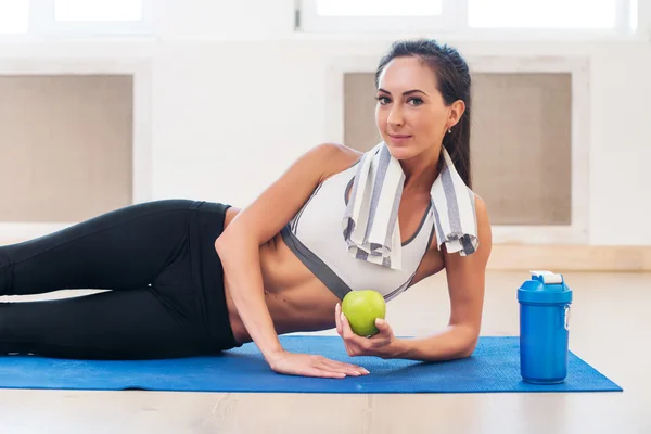 Kaukasiska vackra frisk atletisk sportig tjej med grönt äpple och yogamatta shaker. — Stockfoto