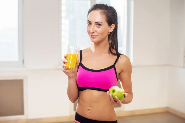 Linda jovem atlética esportiva mulher em roupas esportivas segurando suco de laranja de frutas após o treinamento — Fotografia de Stock