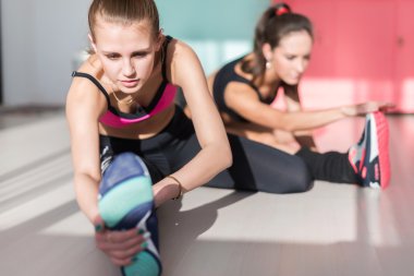 Uygun kadın spor salonu fitness, spor, eğitim ve yaşam tarzı kavramı ısınmak için çalışma germe bacak kasları geri grubu.