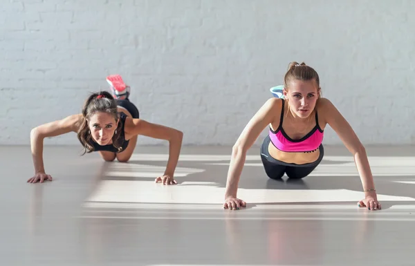 Group of fit women warming up and doing push ups working at gym fitness, sport, training, diet lifestyle concept