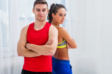 Sportif çift arkadaş ince atletik iddialı kadın ve kendine güvenen adam eğitmenler takım ya da çalıştırıcı istemci geçti silah sporcular kameraya bakarak uzmanları ayakta spor salonu spor salonunda