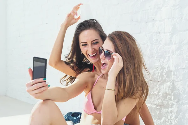 女性朋友笑有好玩的一起穿比基尼文胸泳衣夏天阳光灿烂的日子街道城市休闲风格的以自拍照 — 图库照片