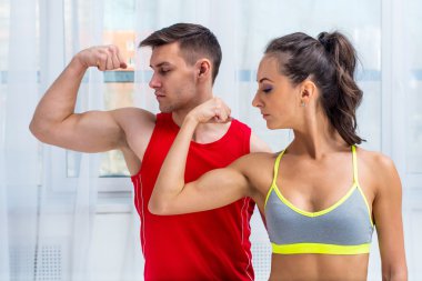 Active athletic sportive woman girl and man showing their muscles biceps healthy lifestyle clipart