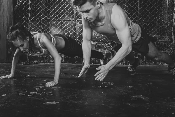 Sporters. passen mannelijke trainer man en vrouw doen ongeëvenaarde push-ups explosieve krachttraining concept crossfit fitness training kracht macht — Stockfoto