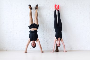 sportsmen woman and man doing a handstand against wall concept balance sport fitness lifestyle people clipart