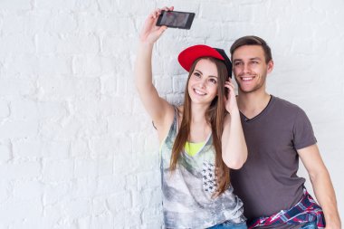 Selfie kendi kendine portre resim fotoğraf ile birlikte kamera veya smartphone eğleniyor yaz giysileri sokak kentsel rahat tarzı giymiş çekici çift arkadaş.