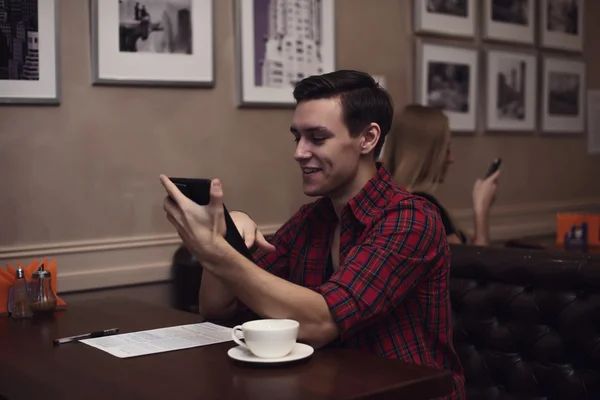 Jeune hipster buvant du café expresso dans le café de la ville pendant l'heure du déjeuner et travaillant la lecture sur tablette — Photo