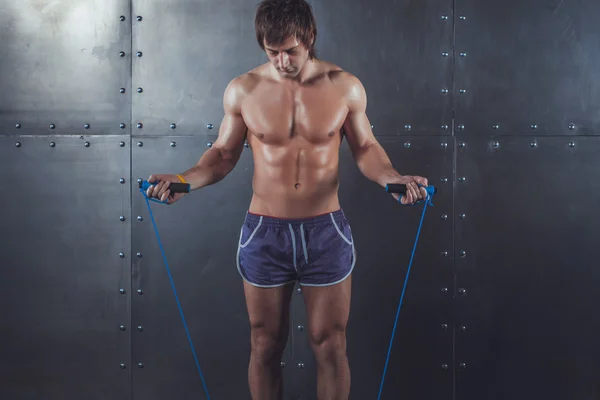 フィットネス モデル筋肉男彼首コピー スペース ヘルシー ボディービルの概念の周りにジャンプ ロープをスキップ. — ストック写真